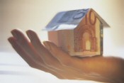 Graphic of hand holding a house made of bank notes